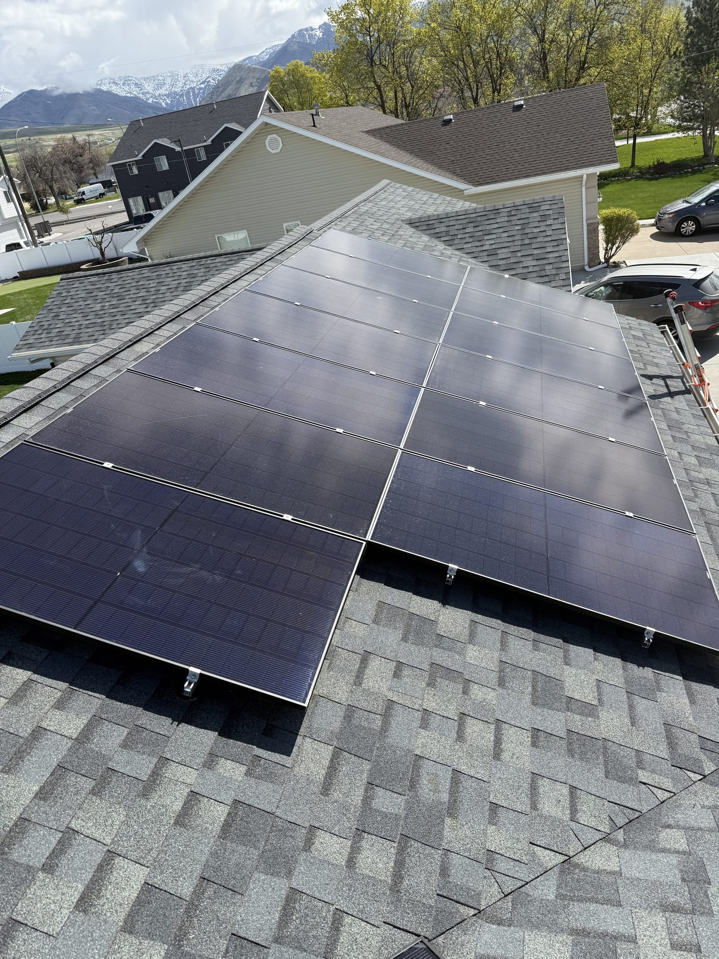 [black-on-black panels] Close-up of solar panels on gray shingle roof from above