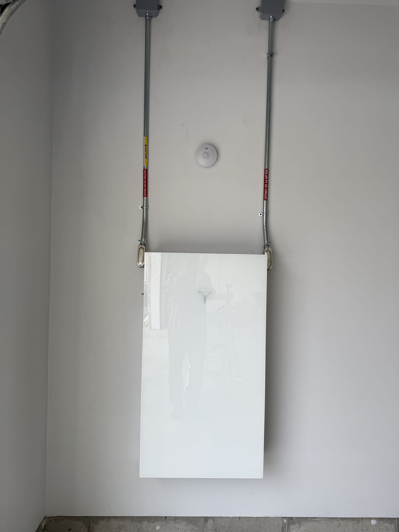 Tesla Powerwall 3 wall mount with conduit and junction boxes in garage