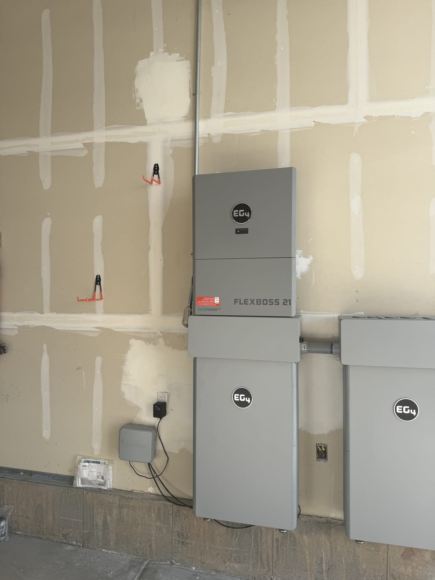 EG4 FlexBOSS 21 and battery units close-up on drywall garage wall