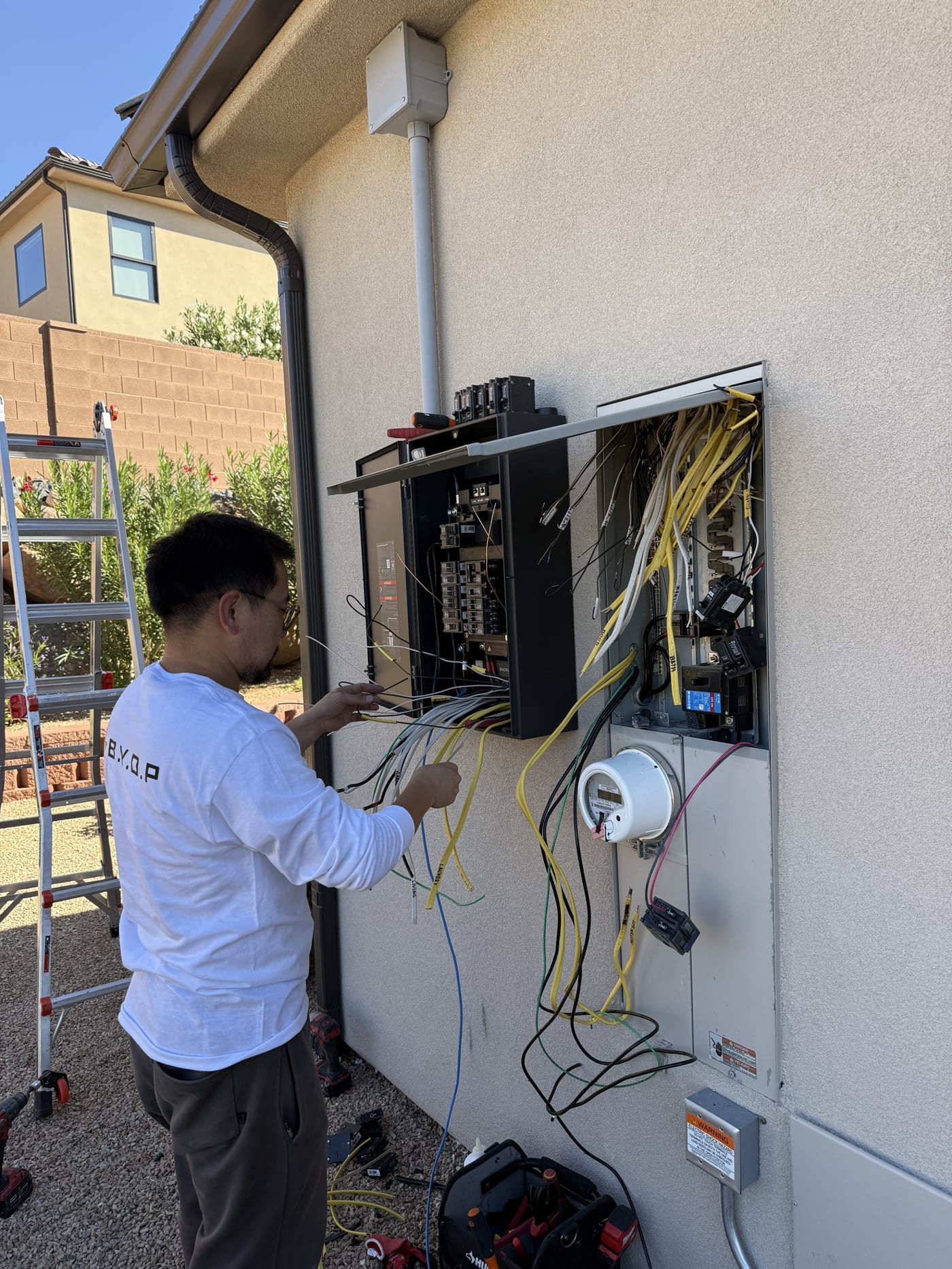Installer connecting wiring to EcoFlow DPU system mounted on exterior wall
