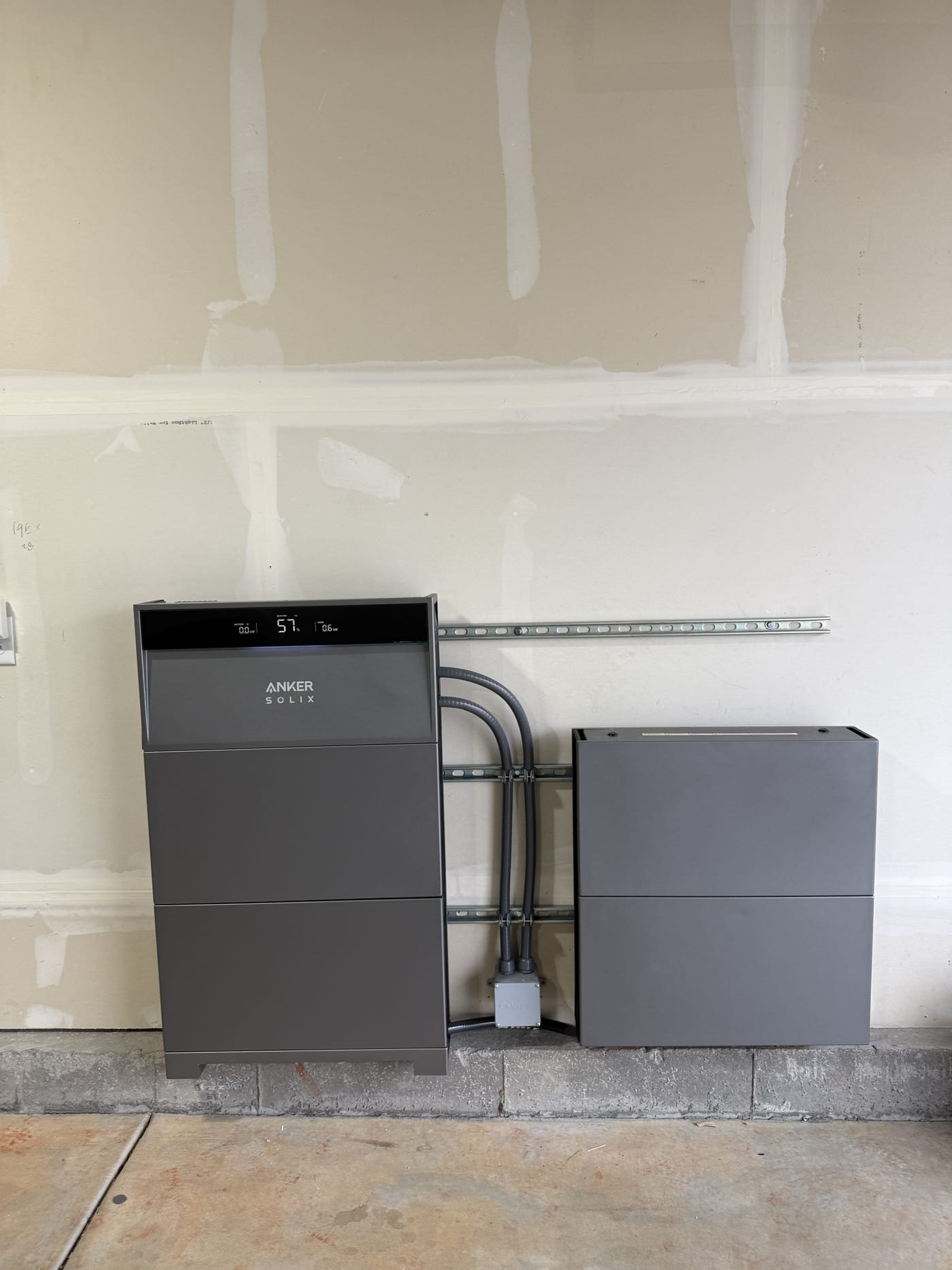 Anker Solix X1 battery system showing brand name and 51 percent charge on utility room wall